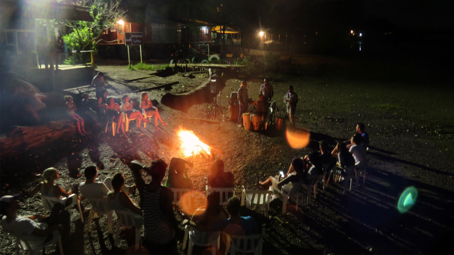 Fotografía de una fiesta nocturna con fogata y música folclórica