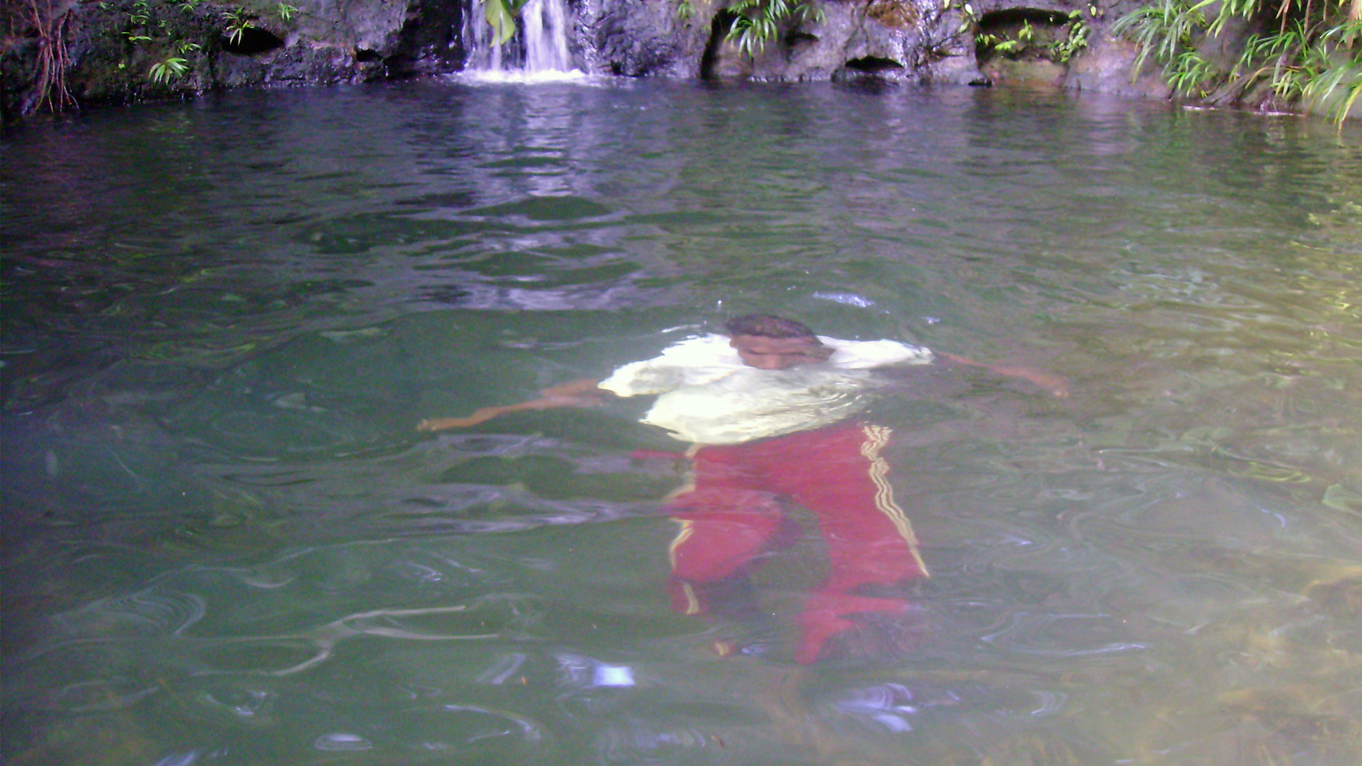 Fotografía de una persona sumergida dentro de la piscina natural